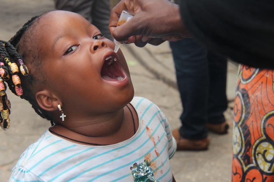 Vaccination d'un enfant de moins de 5 ans contre la polio au marché St Michel à Cotonou au Bénin.